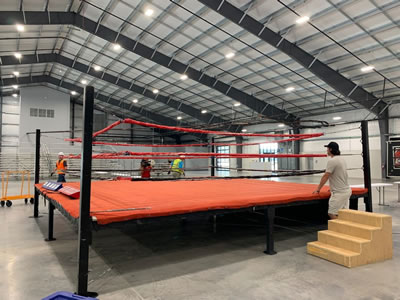 Boxing ring adjustments in preparation for event